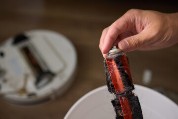 Removing pet fur from a brush and placing it in a bowl as part of grooming routine