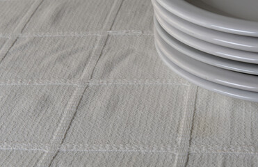 White plates stacked on a table with white tablecloth