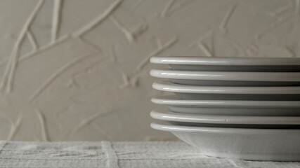 White plates stacked on a table with white tablecloth