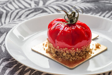 Delicious lactose-free cheesecake shaped like a tomato, trompe l'oeil.