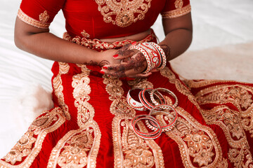Indian bride, bracelets and prepare for wedding, celebration and love for marriage. Woman, sari and...