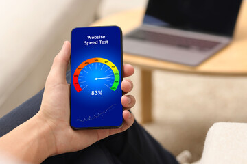 Website speed test. Man using mobile phone at home, closeup