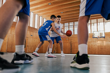Dynamic basketball players playing basketball on training at court.