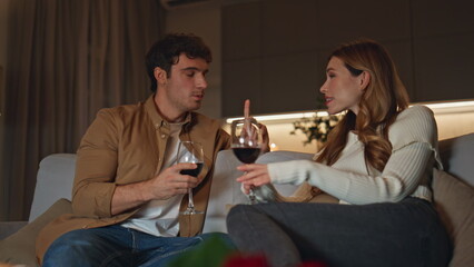 Smiling lovers relaxing couch holding wine glasses close up. Romantic couple 