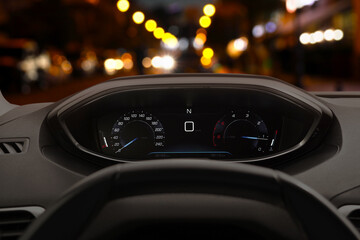 Dashboard with speedometer behind steering wheel inside car