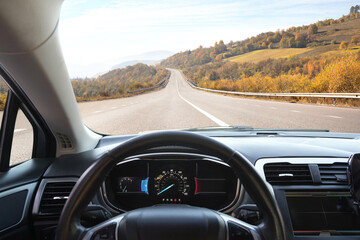 Dashboard with speedometer behind steering wheel inside car