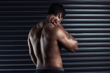 Obraz premium Neck pain, athlete and man with injury and body ache in fitness training, exercise or workout. Dark background, sore muscles or sports person with bruised spine in accident, gym studio or emergency