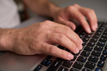 Hands typing on a mechanical keyboard in a workspace, enhancing productivity and focus