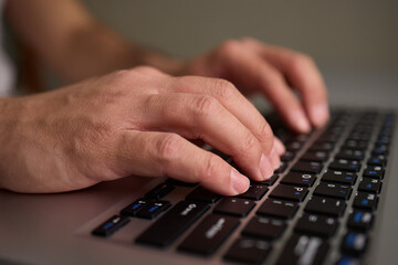Hands typing on a mechanical keyboard in a workspace, enhancing productivity and focus