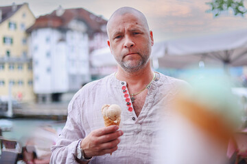 European tourist eating ice cream standing at street outside