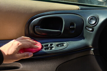 A person is seen holding a pink object near the air vent of a car