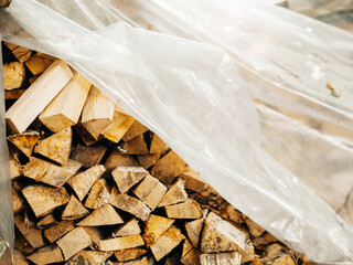 A pile of wood logs with some of them being cut. The pile is in the sun and has a rustic feel to...