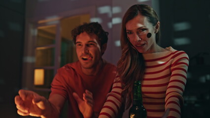 Fototapeta premium Man win beer pong throwing ball at night home party close up. Woman drinking