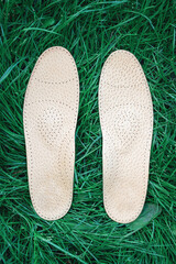 Orthopedic insoles for shoes on a background of green grass