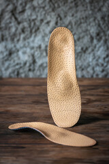 Orthopedic insoles for shoes on a wooden background