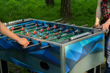 Mens playing table football outdoors.