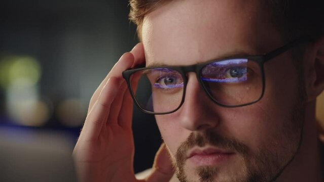 Close up shot of wearing glasses with reflect ukrainian attacked by russia in 2022 february. Video flashbacks about russian invasion. Upset man shocked looking first cadres from Bucha