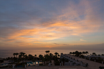 Sunrise on the sea coast. The movement of the sun and clouds across the sky. Park recreation areas of Egypt. Garden and landscape design.