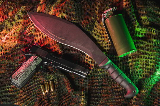 Photo of weapons, M1911 pistol, tactical kukri and smoke grenade.