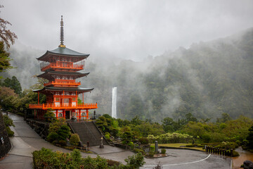Seiganto-ji Temple Pagoda with Nachi Falls behind on Kumano Kodo hiking trail, April, Japan
