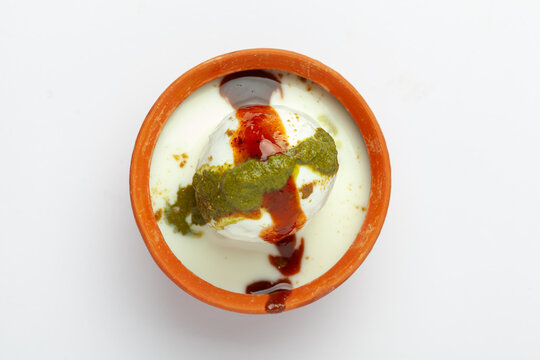 Chaat Dahi vada (AKA Dahi Bhalla, Doi Bora, mosaru vade, Dahi Bara, thayir vadai, perugu vada ). Prepared by soaking  (yogurt). Garnished with tamarind and coriander chutney.