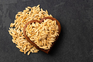 Risoni, organic pasta in heart shaped bowl - Raw dried orzo
