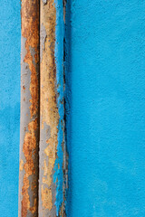 Rusty pipes on painted blue wall background