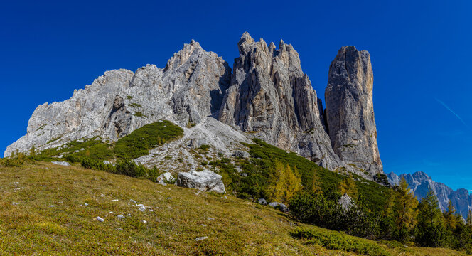 Panorama of the Dolomites mountains on a sunny day, blue sky with soe clouds. Beautiful mountians of Alpi Dolomiti in Italy, South Tirol alpine range in autumn