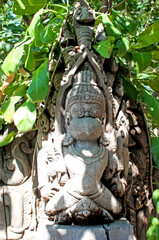 Appreciate the intricate stone carving set within the lush greenery of its surroundings