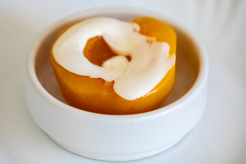 Traditional dessert of peaches in syrup with cream
