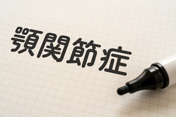 顎関節症と書かれたノートとマーカー