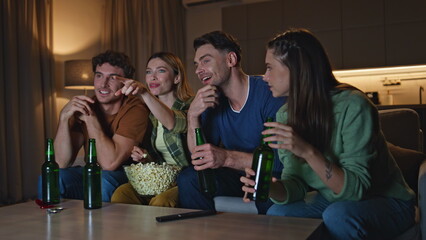 Carefree friends enjoy tv film sitting cozy home couch. People discussing show