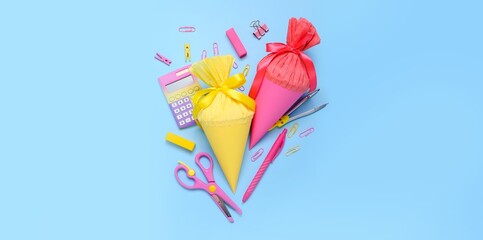 School cones with stationery on light blue background