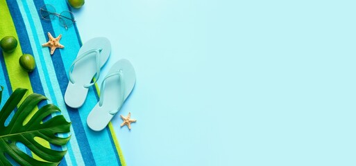 Composition with beach accessories, limes and palm leaf on light blue background with space for text
