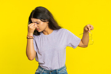 Exhausted tired Indian young woman takes off glasses, feels eyes pain, being overwork burnout from...