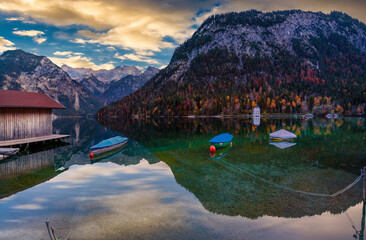 boats waiting in the reflective water clouds in the sky sunset colors