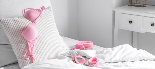Bed with bra, collar and handcuffs from sex shop in morning