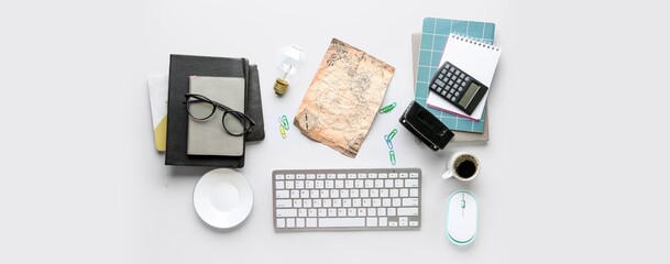 Modern computer keyboard, pc mouse, cup of coffee, world map and stationery on light background