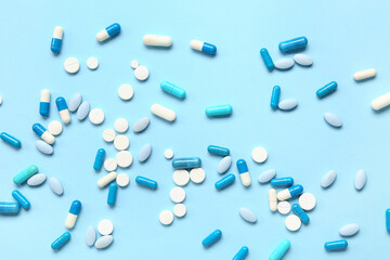 Many different pills on blue background