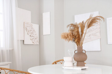 Vase with pampas grass on dining table in stylish room