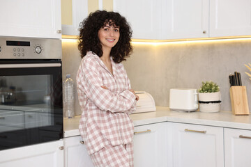 Beautiful young woman in stylish pyjama in kitchen