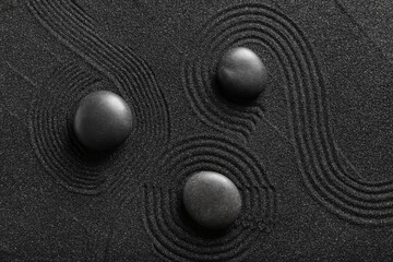 Spa stones on black sand with lines. Zen concept