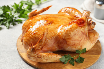 Tasty roasted chicken with parsley on light grey table