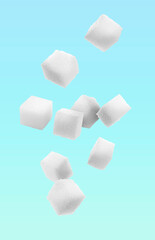 Refined sugar cubes in air on light blue background