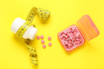 Container and bottle with weight loss pills on yellow background
