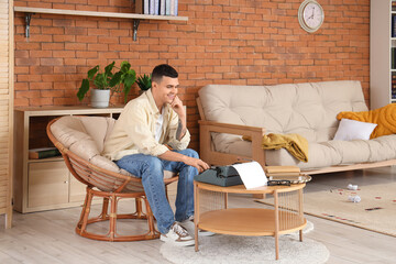 Male author typing on vintage typewriter at home