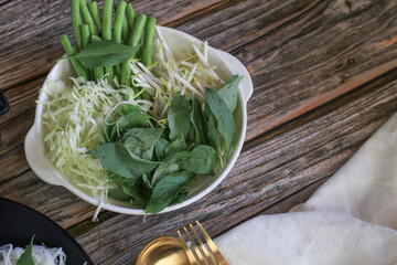 Vegetable set - Bean sprout, basil, cabbage and asparagus bean on wooden table eat with Kanom Jeen. Thai authentic food