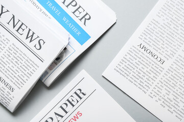 Obraz premium Different newspapers on grey background
