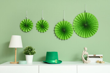 White cabinet with leprechaun's hat, paper fans and gold in festive living room. St. Patrick's Day...