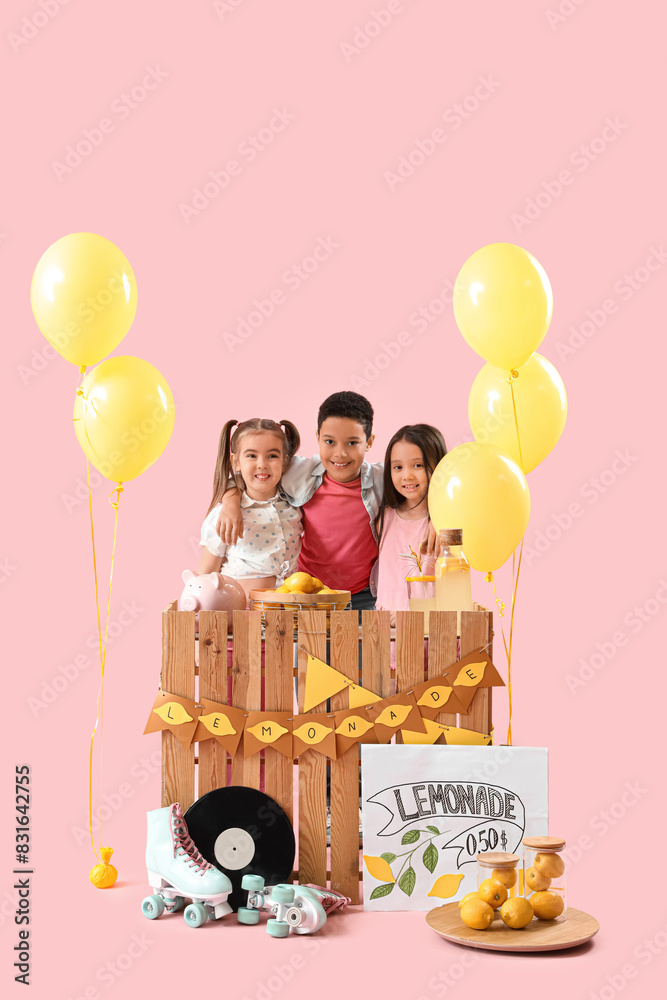 Wall mural Cute little children hugging at lemonade stand on pink background